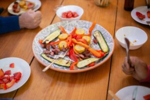 A colorful arrangement of roasted vegetables and meat on a dinner table, perfect for sharing and enjoying with family or friends.