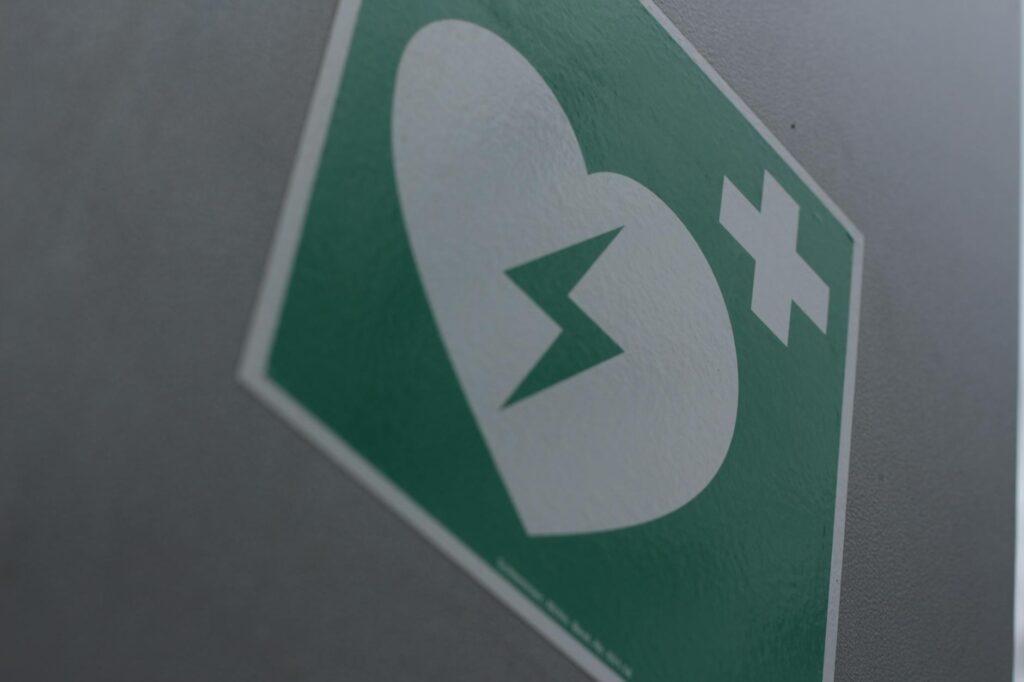 pexels-photo-249348-249348 Green first aid sign featuring a broken heart and cross symbol for medical emergency awareness.