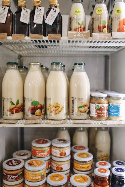 pexels-photo-3735169-3735169 A variety of plant-based milk bottles on display in a refrigerator, showcasing vegan and dairy-free options.
