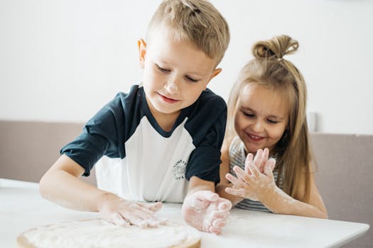 pexels-photo-4784044-4784044 Two happy children enjoying baking, covered in flour while preparing dough at home.