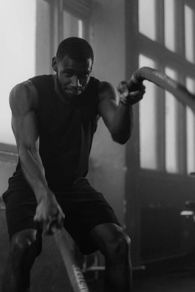 pexels-photo-6389075-6389075 Focused man in gym intensively training with ropes indoors.