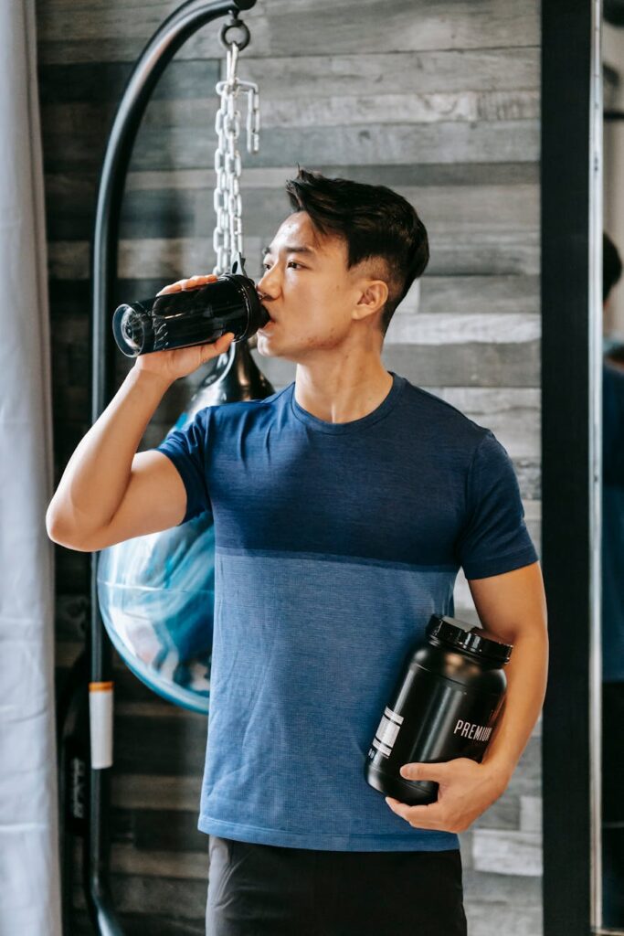 pexels-photo-6551145-6551145 Athletic man hydrating with protein shake during workout in gym.