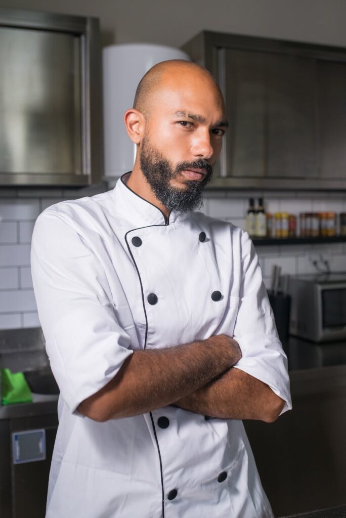 pexels-photo-8629122-8629122 Portrait of a professional chef standing confidently in a modern kitchen setting.