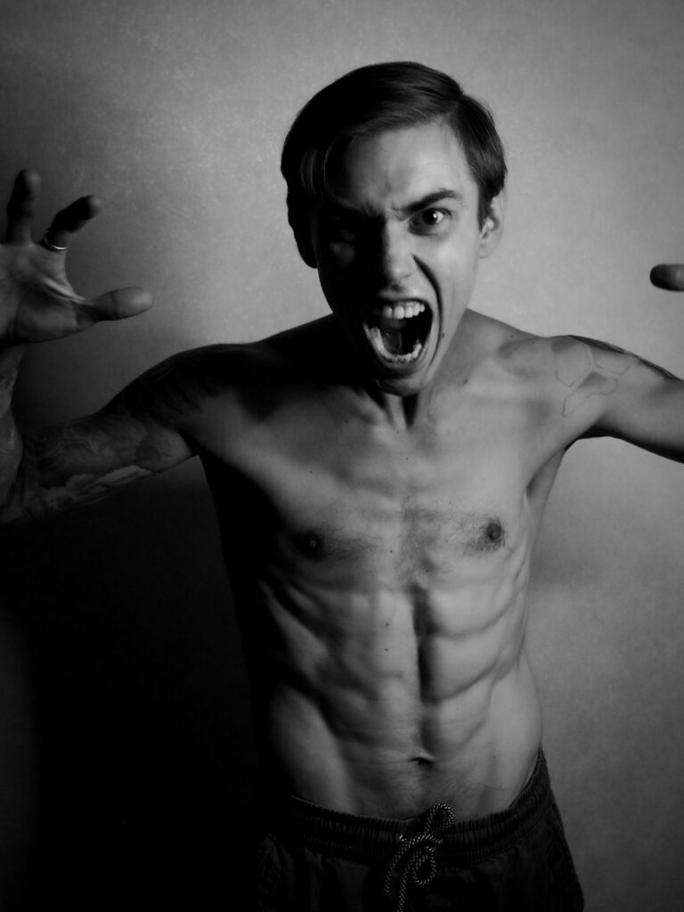 pexels-photo-9440988-9440988 Dramatic black and white portrait of a shirtless man expressing anger with intense facial expression.
